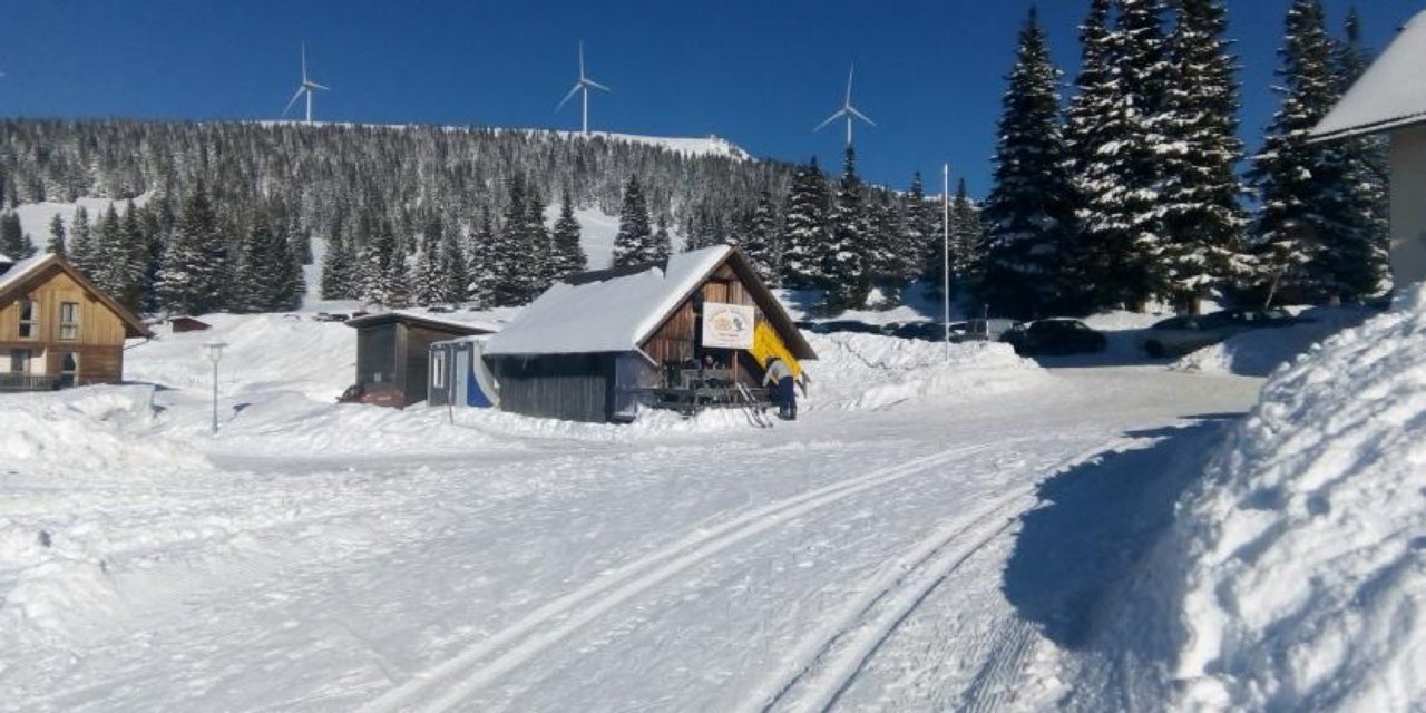 Langlaufspur bei einem verschneiten Gebäude auf der Weinebene