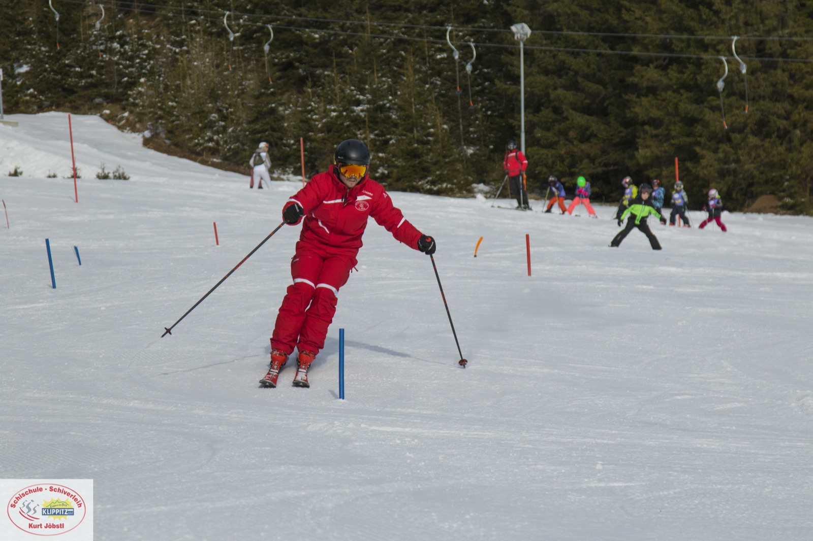 Skilehrer in roter Jacke bei einer Kurvenfahrt